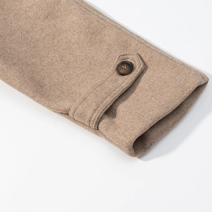 Detailed close-up of wool coat cuff with adjustable strap and dark brown button