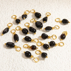 Macro shot of irregular black natural stone pendants with gold plated bail hooks