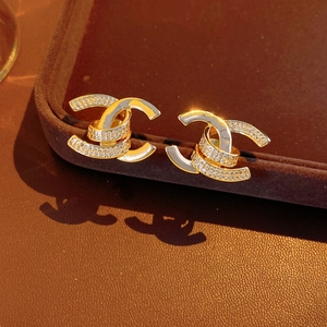 Detailed close-up of 18k gold plated double C stud earrings with sparkling zircons