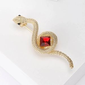 Detail of vintage cobra brooch with scales texture and red gemstone center