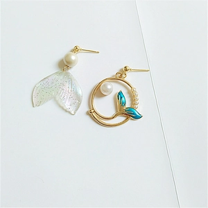 Detail of asymmetric mermaid tail earrings with blue resin, pearls and gold ring