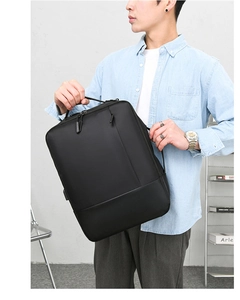 Detail view of black business laptop backpack showing side handle and sleek matte finish