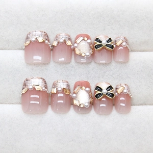 Faux ongles œil de chat avec perles, nœuds 3D et paillettes en rose nude