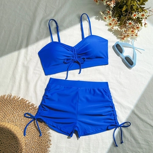 Detail of royal blue two-piece swimsuit with side drawstring and adjustable bow tie