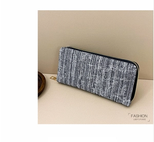Close-up of grey and white tweed texture on a women's long zipper wallet with gold metal zipper