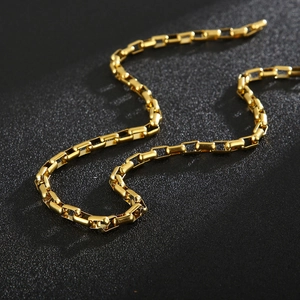 Detail of a 5mm gold box chain link necklace showing polished texture and metal luster