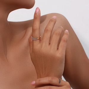 Detail of adjustable gold-plated crossover ring with clear zircons on model's finger