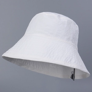 Close-up of a white outdoor bucket hat showing fabric texture and adjustable wind rope