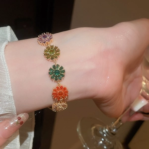 Detailed shot of 18k gold plated bracelet with five colorful zircon flower charms