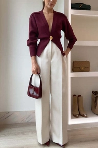 Cardigan in maglia con scollo a V rosso scuro e pantaloni bianchi a gamba larga