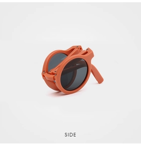 Detailed side view of orange foldable children's sunglasses in a compact storage state
