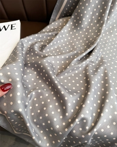 Nahaufnahme der grauen Seidenschal-Textur mit Polka-Dots, elegantem Fall und glatter Haptik