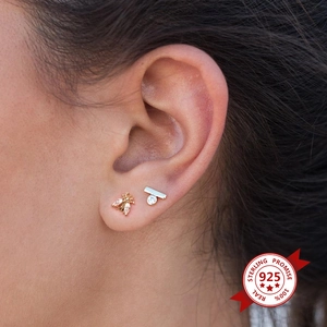 Detail shot of asymmetric bee and crystal stud earrings in 925 sterling silver
