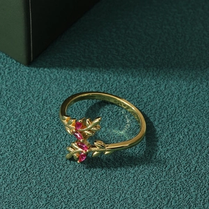 Exquisite gold leaf ring with micro-set zircon and red ruby on a dark green surface