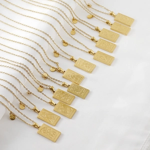 Macro shot of 18K gold zodiac constellation pendants on stainless steel square necklaces