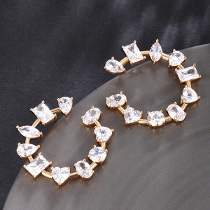 Macro shot of gold earrings with mixed-cut heart and teardrop cubic zirconia stones