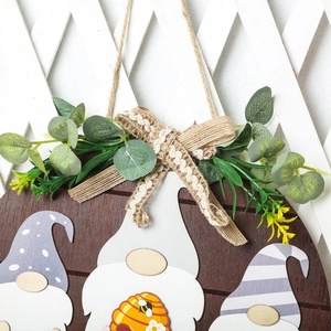 Detail of wooden welcome sign featuring a burlap bow and realistic eucalyptus leaves