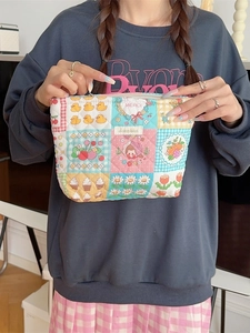 Quilted cotton makeup bag with colorful cartoon floral patches and top zipper closure