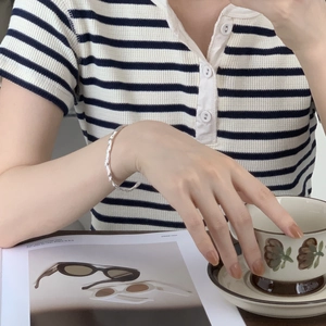 Detailed view of silver open cuff bracelet with hammered texture on a model wrist