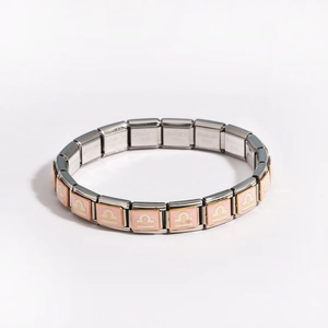 Close-up of pink Libra zodiac charm on modular stainless steel Italian link bracelet