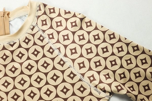 Detail of a slim-fit khaki long sleeve bodysuit with retro geometric print and neck zipper