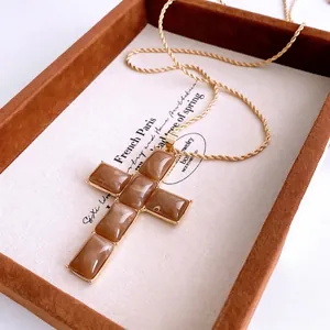 Vintage gold twist chain necklace with a resin cross pendant featuring brown gemstones