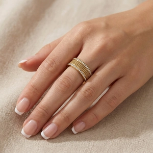 Close-up of golden mesh weave ring with sparkling white zircons worn on model finger