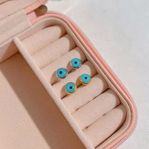 Gothic evil eye stud earrings in gold and silver plating displayed in a jewelry box