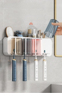 Wall-mounted toothbrush holder detail with four inverted cups and storage compartments