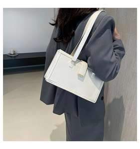 Detail showing the white rectangular shoulder bag with fine leather texture on a model