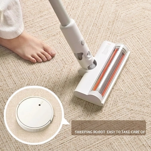 White smart robot vacuum cleaner on a vintage French carpet with high-efficiency brush