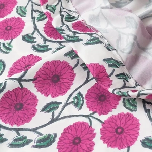 Détail du tissu à fleurs avec marguerites roses et feuilles vertes sur fond blanc