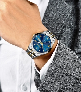 Close-up of blue sunburst dial with gold Roman numerals and day-date display on luxury watch