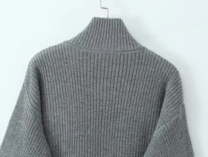 Detailed macro view of gray chunky knit texture on long cardigan sweater