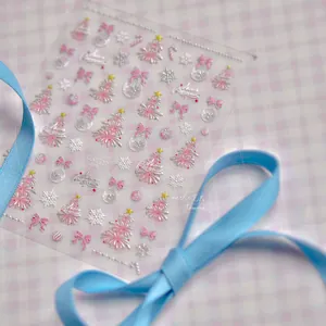 Detailed view of Christmas nail stickers with pink trees, silver snowflakes and bows
