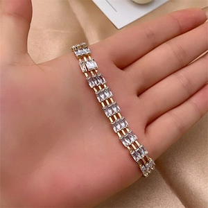Detailed close-up of a three-row gold-plated bracelet with baguette-cut cubic zirconia