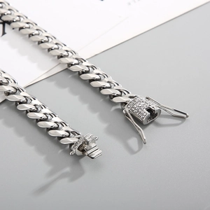 Macro shot of silver Cuban link chain with detailed diamond-encrusted box clasp closure