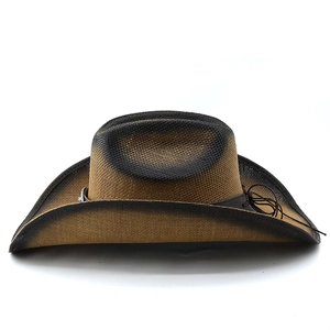 Detail of two-tone woven straw cowboy hat with distressed edges and leather hat band