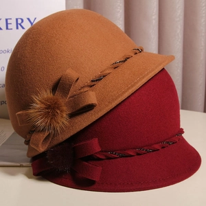 Detail of wool bucket hats with bow, fur pompom and sequin trim in caramel and burgundy