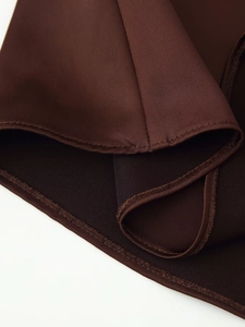 Detailed macro view of chocolate brown satin fabric texture and double-stitched hem