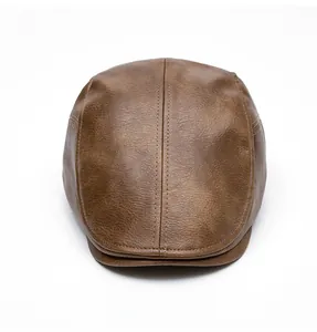 Close-up of brown leather flat cap showing detailed stitching and premium grain texture
