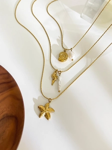 Close-up of gold layered starfish shell necklace with elegant freshwater pearls