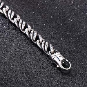Détail d'un bracelet gourmette en acier inoxydable avec un fermoir mousqueton robuste