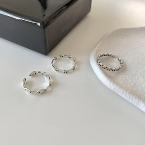 Detail of S925 sterling silver rings showing wave and oval geometric link patterns