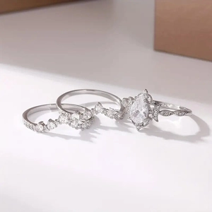 Macro shot of three-piece silver ring set with pear-shaped center stone and vintage accents