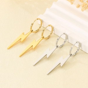 Macro shot of polished gold and silver lightning bolt pendants on earring hoops