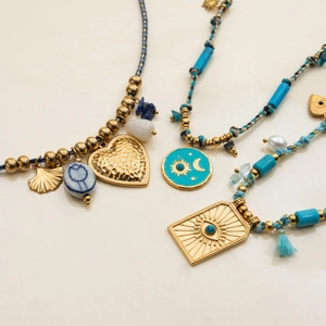 Flat lay of vintage turquoise beaded necklaces with gold stainless steel pendants