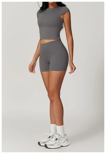 Vista laterale degli shorts da yoga grigio scuro a vita alta e crop top su modella