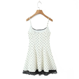 Detail of white polka dot dress with delicate black lace trim and adjustable straps