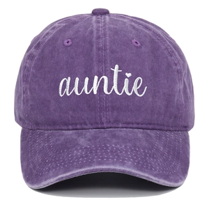 Detail der weißen auntie Stickerei mit Herz auf lilafarbener gewaschener Baumwollkappe